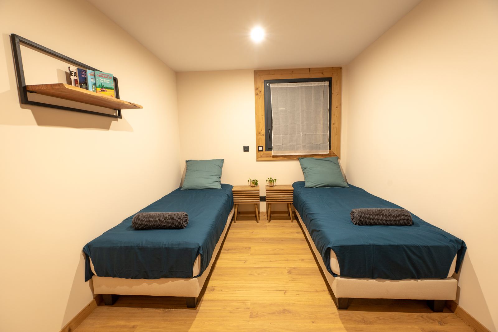 Chambre avec deux lits simples et bibliothèque